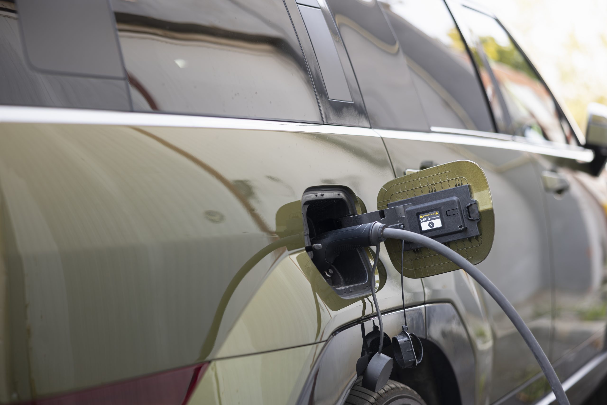 Close up shot of EV plug connected to electric car, concept of eco friendly technology. Electric SUV automobile charging at modern station, showcasing clean energy transportation